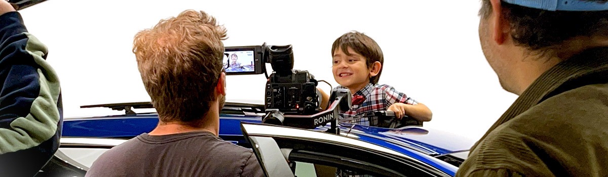 Happy child filming car commercial